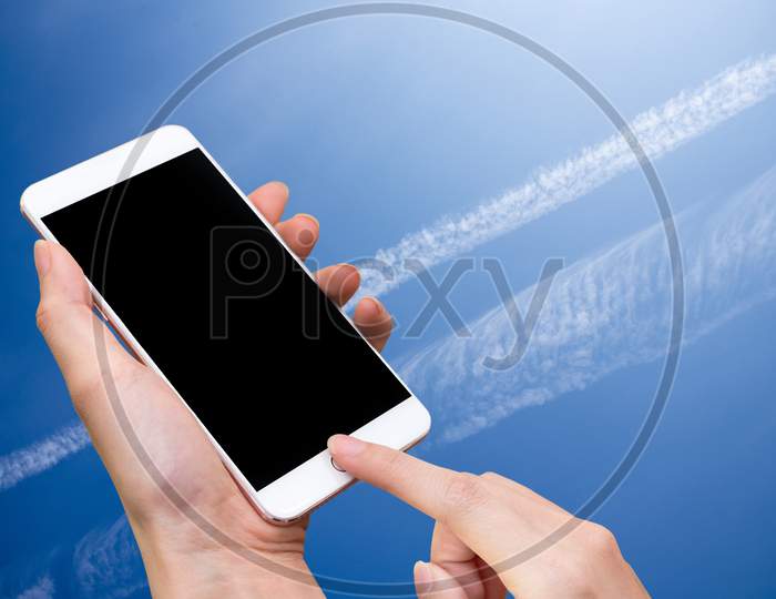 Woman Hold Smart Phone And Touch Button By Hand With Blank Screen For Advertisement, Blue Sky And Abstract Background ,Technology And Nature Concept