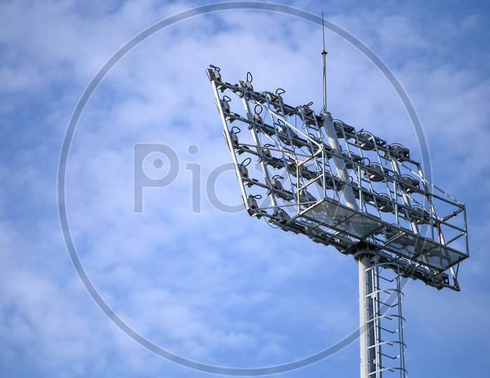 Sport Stadium Spotlight With Blue Sky Background. Football And Soccer Light Lamp