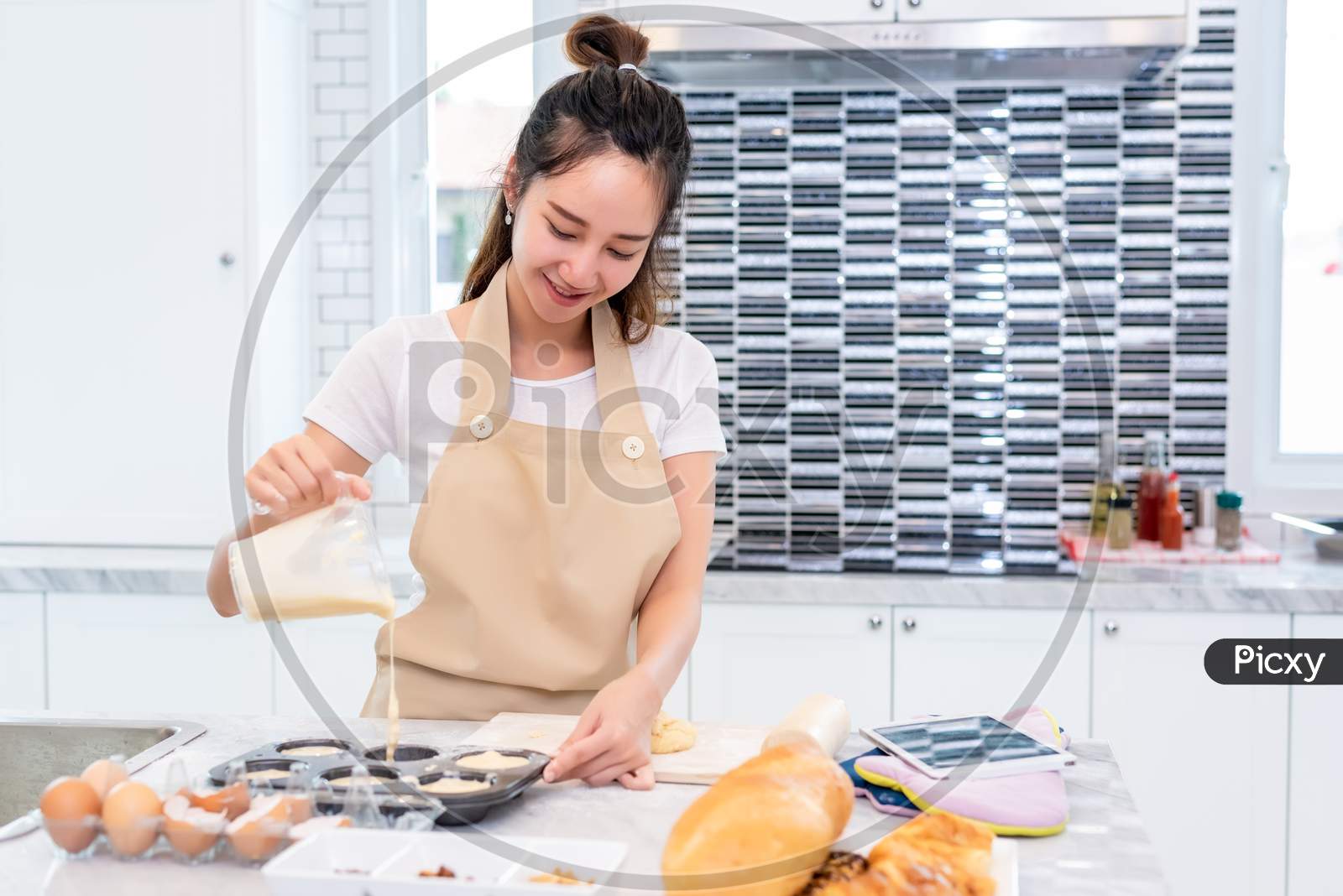 Asian Beauty Woman Cooking And Baking Cookies In Kitchen Room On Table. Holiday And Happiness Concept. People And Lifestyles Concept. Family And Dinner Party Theme. Girl Enjoy Making Cake With Apron