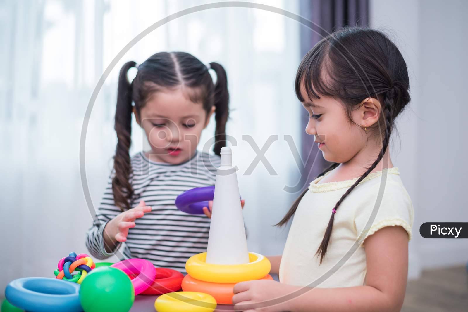 Two Little Girls Playing Small Toy Balls In Home Together. Education And Happiness Lifestyle Concept. Funny Learning And Children Development Theme. Smile Faces