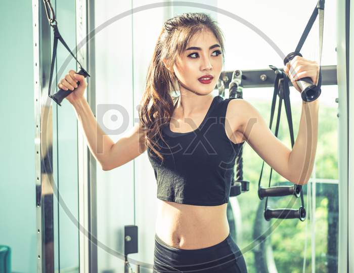 Asian Young Woman Doing Elastic Rope Exercises At Cross Fitness Gym. Strength Training And Muscular. Beauty And Healthy Concept. Sport Equipment And Sport Club Center Theme.