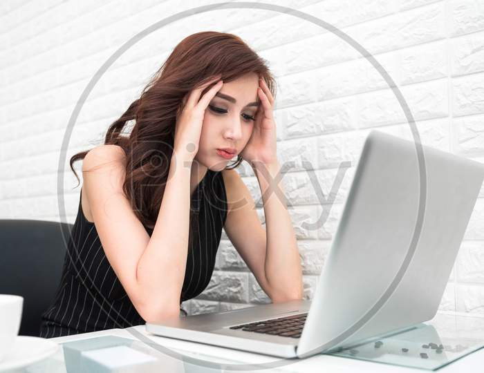 Asian Woman Who Work Seriously When Doing And Starting Up Business With A Laptop In Office. Business Ideas And Disappointment Concept. Business Project And Stress Concept. Technology And People Theme.