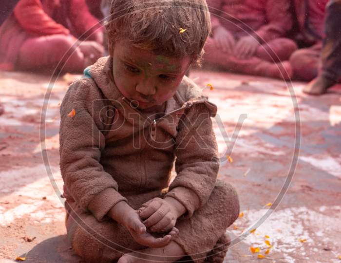 Indian Kid celebrating Colorful Holi festival at Barsana