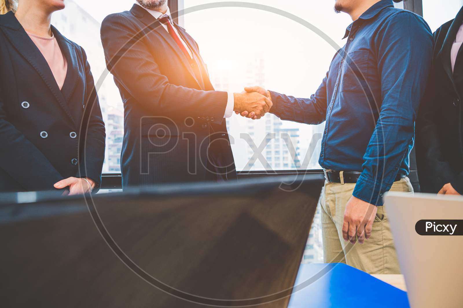 Business Partnership Meeting Handshaking Concept. Businessmen Doing Handshake. Successful Business People Contract Handshaking After Finished Good Dealing With Skyscraper Window Building Background.