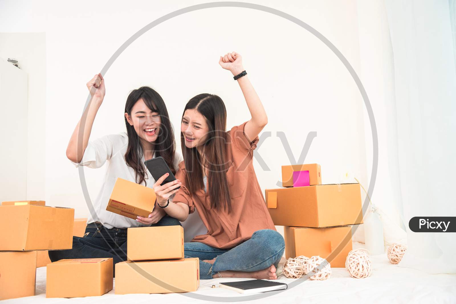 Two Young Asian Woman Startup Small Business Entrepreneur Sme Distribution Warehouse With Parcel Mail Box. Owner Home Office. Online Marketing And Product Packaging And Delivery Service. Happy Gesture