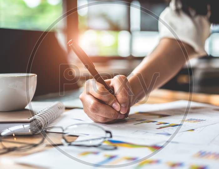 Close Up Of Businesswoman Hand Writing Summary Report Data. Marketing And Business Ownership Concept. People And Lifestyles Concept. Business Employee And Financial Theme