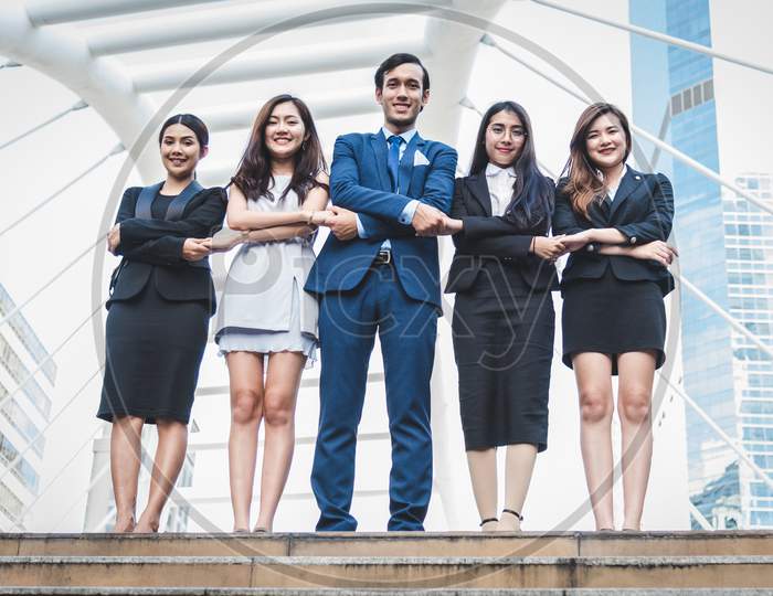 Portrait Of Successful Group Of Business People At Outdoor Urban. Happy Businessmen And Businesswomen Standing As Team In Satisfaction Gesture. Successful Group Of People Smiling And Looking At Camera