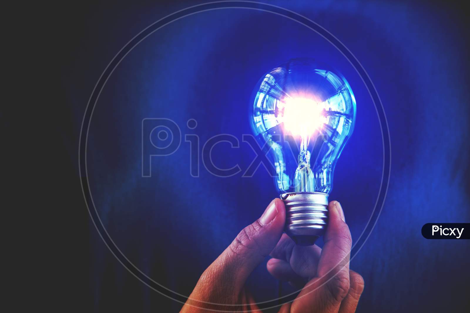 Bulb With Lighting. Idea And Creative Concept  For Startup New Project. Technology Object And Electrical Part Theme. Energy And Power Saving Theme. Copy Space In The Left Side. Blue Filter Background