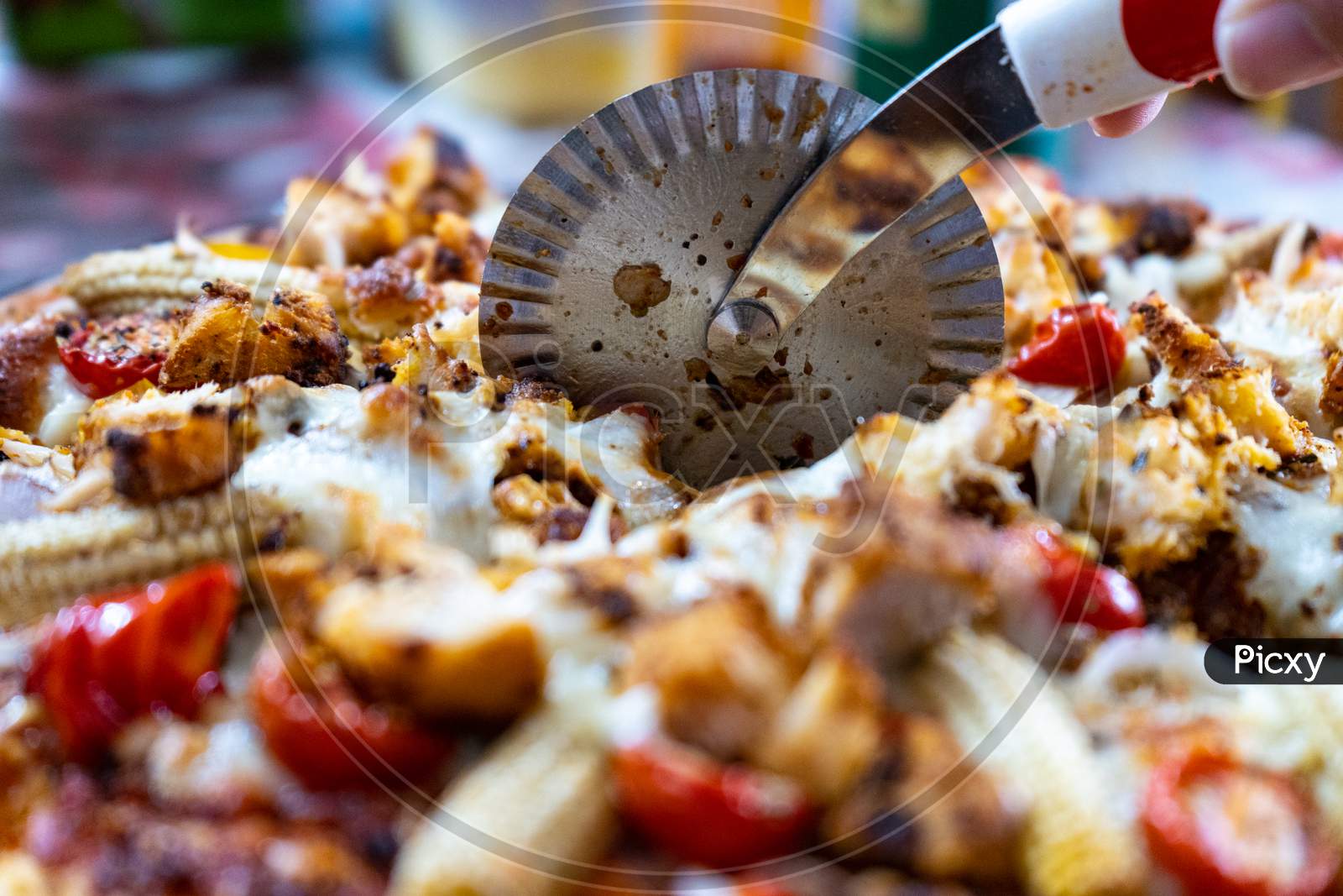 image-of-macro-view-of-a-circular-pizza-cutter-cutting-through-a-pizza-filled-with-cheese-baby