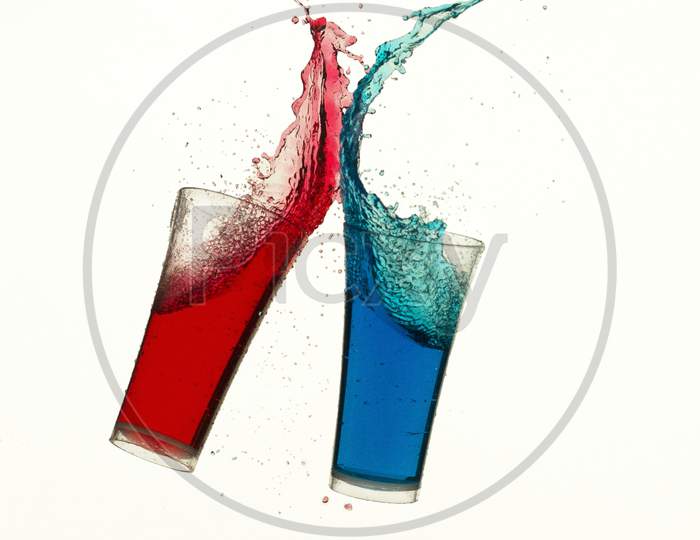 The red and blue glasses are hitting each other and making splash
