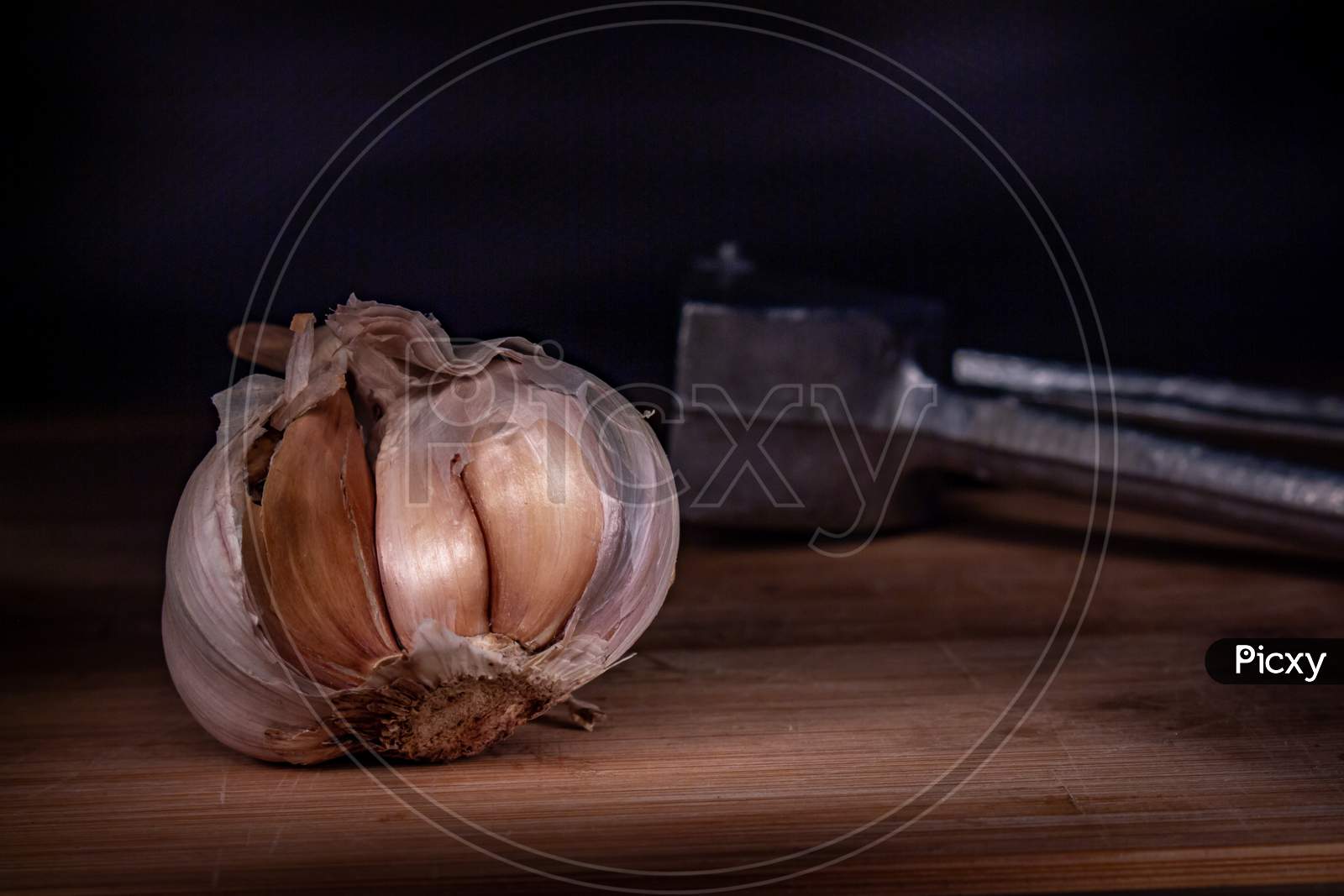 Garlic Head On A Wooden Board. Black Background With Free Space To Write.