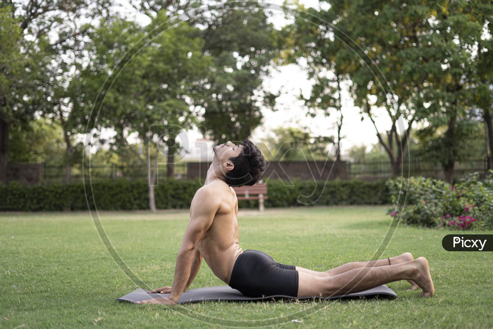 A Young Indian Shredded Teenage Boy Doing Yoga Aasan In The Park On International Yoga Day