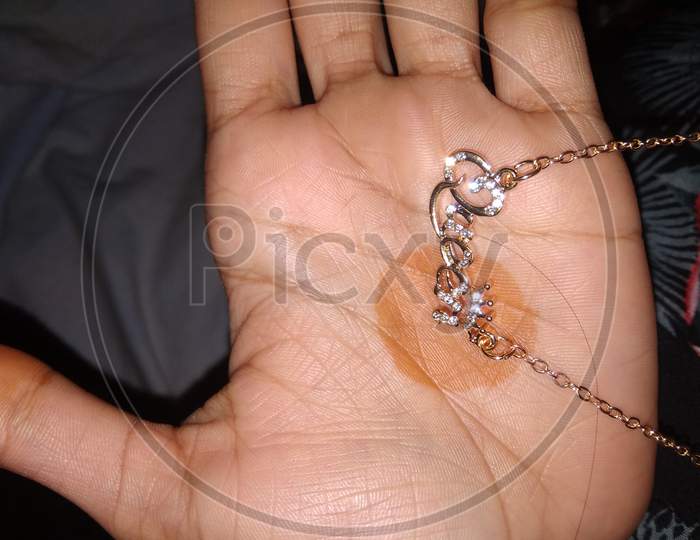 A girl hand with beautiful queen pendant.