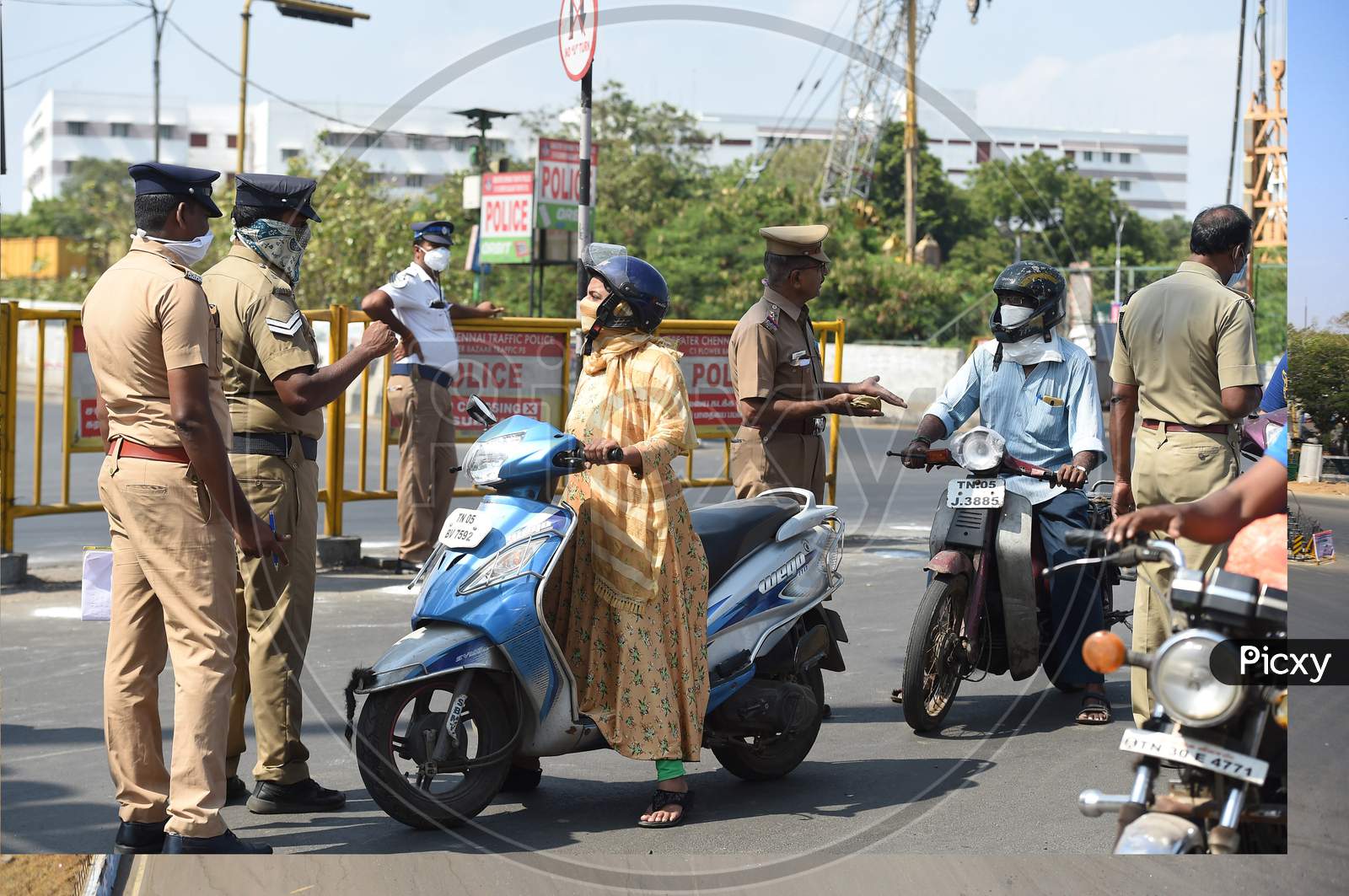 Commuters wait as a police personnel checks for valid travel credentials after a lockdown was reimposed as a preventive measure against the spread of the COVID-19 coronavirus, in Chennai on June 19, 2020. The epidemic has badly hit India's densely populated major cities and Chennai in the south has