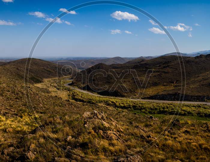 Beautiful Panoramic View Of The San Luis Mountains In Argentina. Highway Runs Between Arid Mountainous Soil. Mountainous Landscape