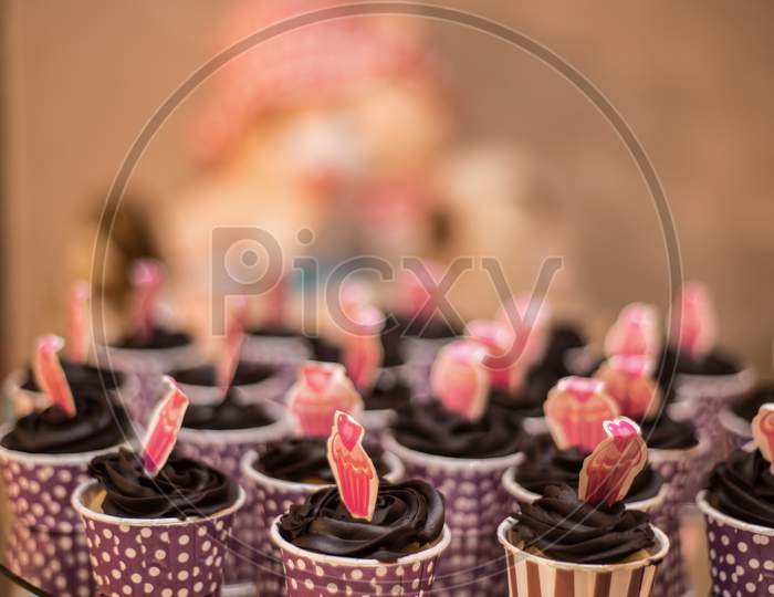 Close view at tasty chocolate cup cakes over wooden background