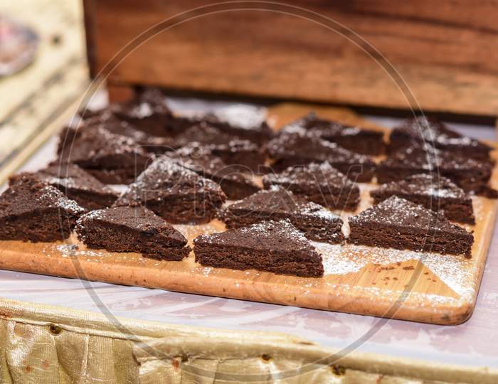 A stack of chocolate brownies on wooden background, homemade bakery and dessert.