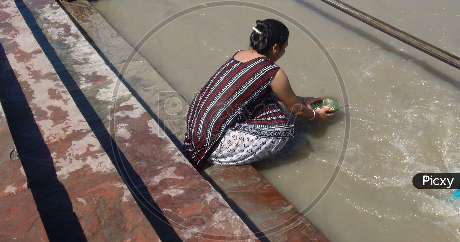 a woman offering her prayers to river Ganga