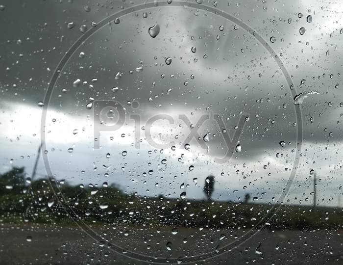 Car window Glass Rain drops nature view on the way