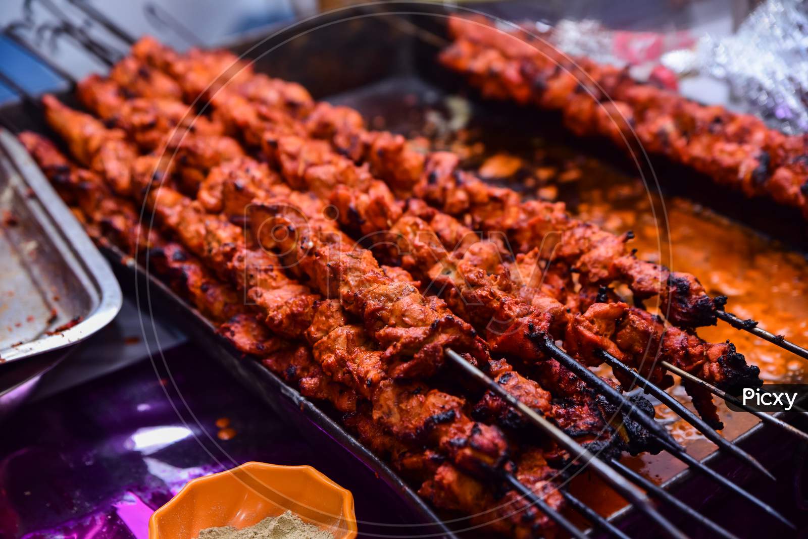 Barbecue Chicken Kebabs On The Hot Grill Close-up. Flames of Fire In The Background