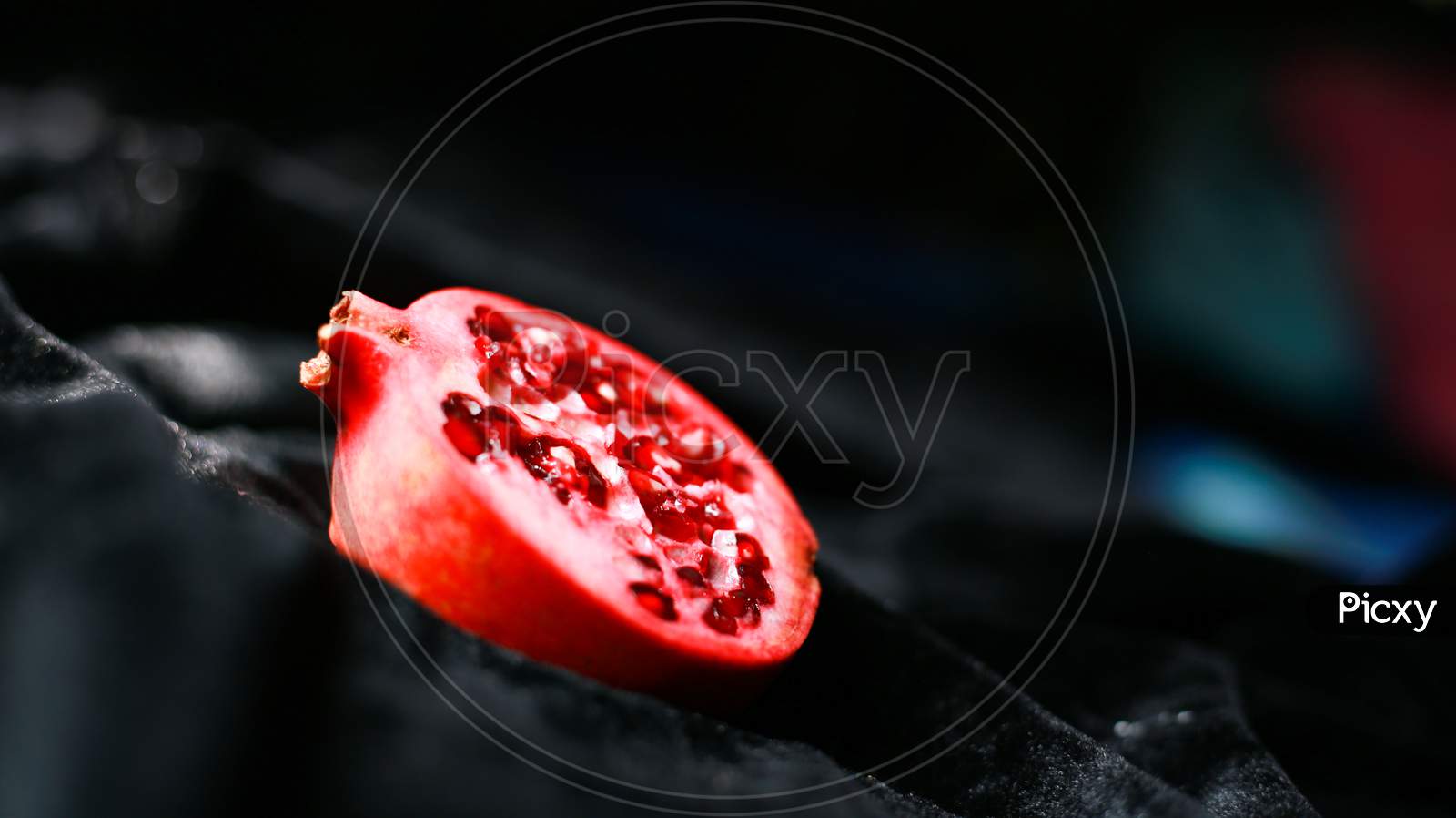 Fresh juicy pomegranate piece on dark background