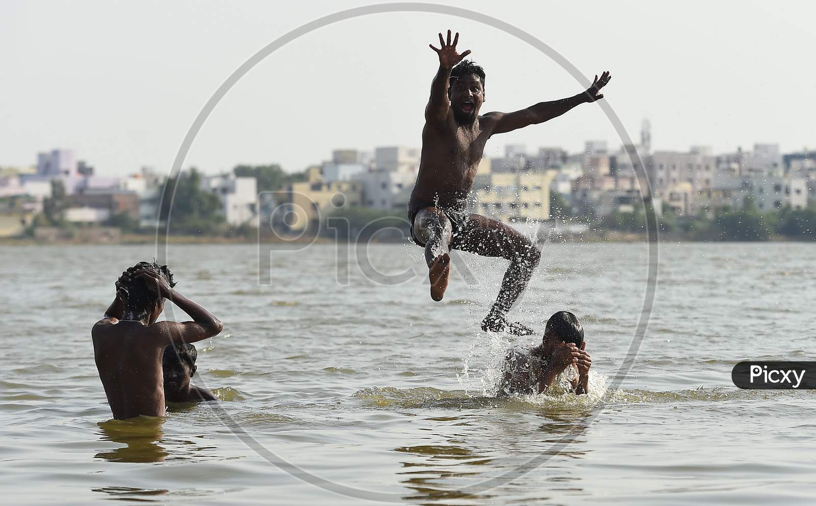 People Swim In A Lake To Beat The Heat on the Outskirts Of Chennai.