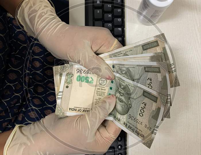 Woman Counting Money Putting Gloves And Sanitizer On Hand.