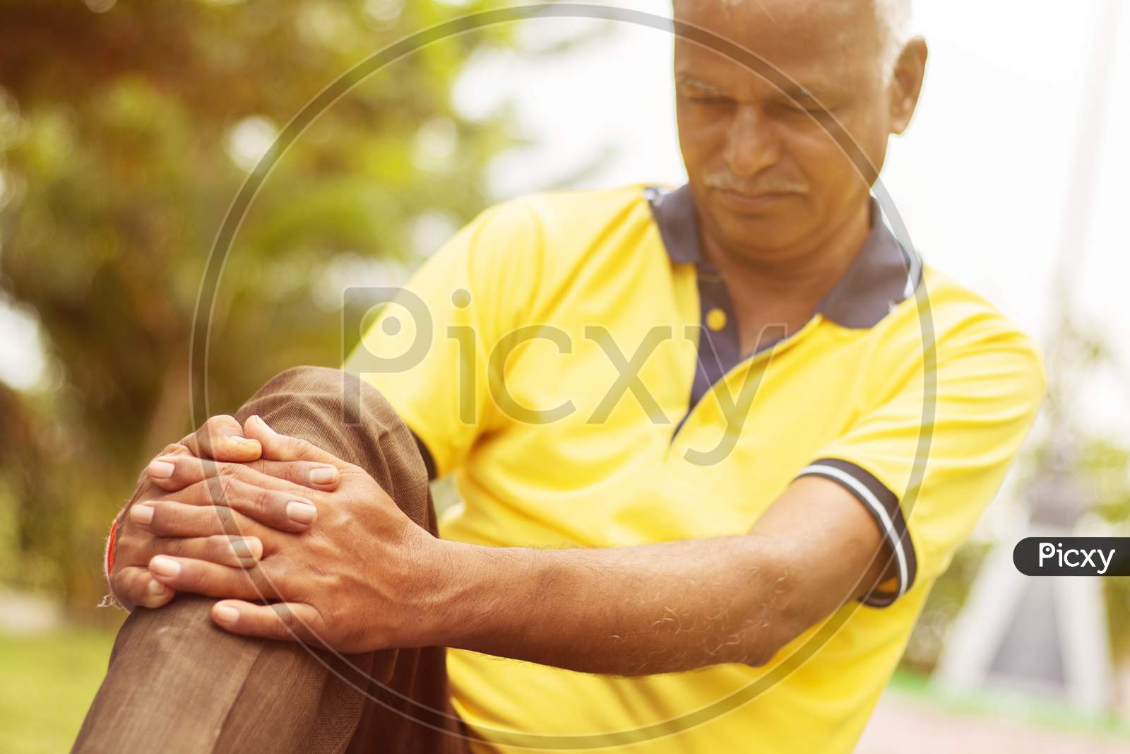 Elderly Man Having A Knee Injury - Concept Senior Man Fitness And Yoga At Outdoor - Selective Focucs On Hand, Old Man Holding Knee Due To Pain.