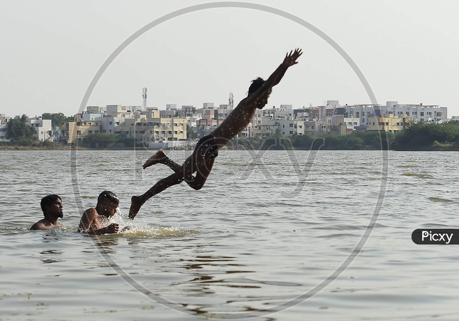 People Swim In A Lake To Beat The Heat on the Outskirts Of Chennai.
