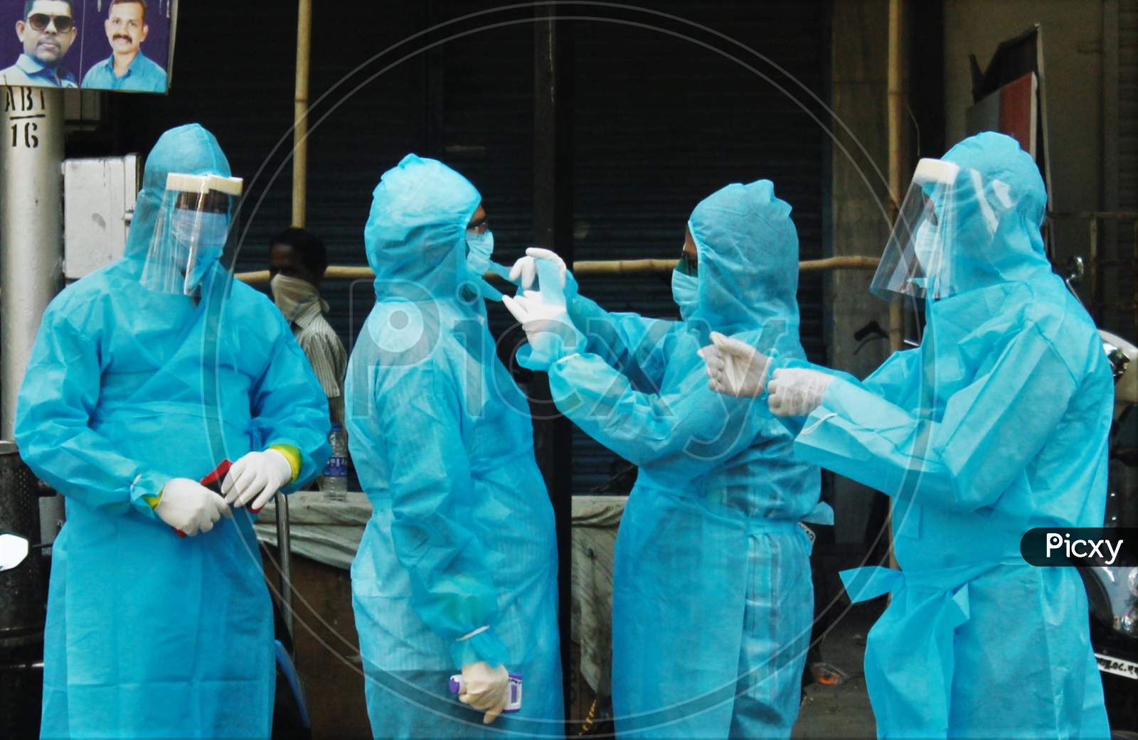 Healthcare workers wearing protective suits help each other to wear a mask before going to visit a slum area at Worli to test the residents for coronavirus during the nationwide lockdown to limit the spreading of coronavirus disease (COVID-19) in Mumbai, India on April 20, 2020.