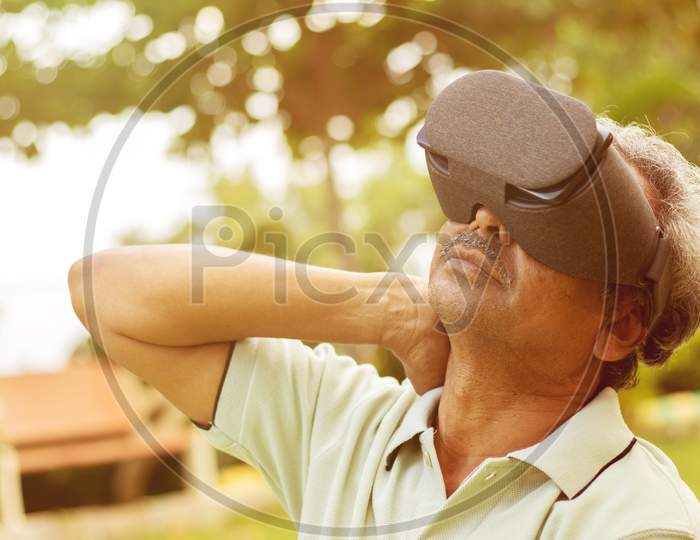 Senior Man Using Vr Google Glass For Exercise, Outdoor - Fitness Concept Using New Technologies By Elderly People - Old Men Stretching Hands By Watching Virtual Reality Goggles.