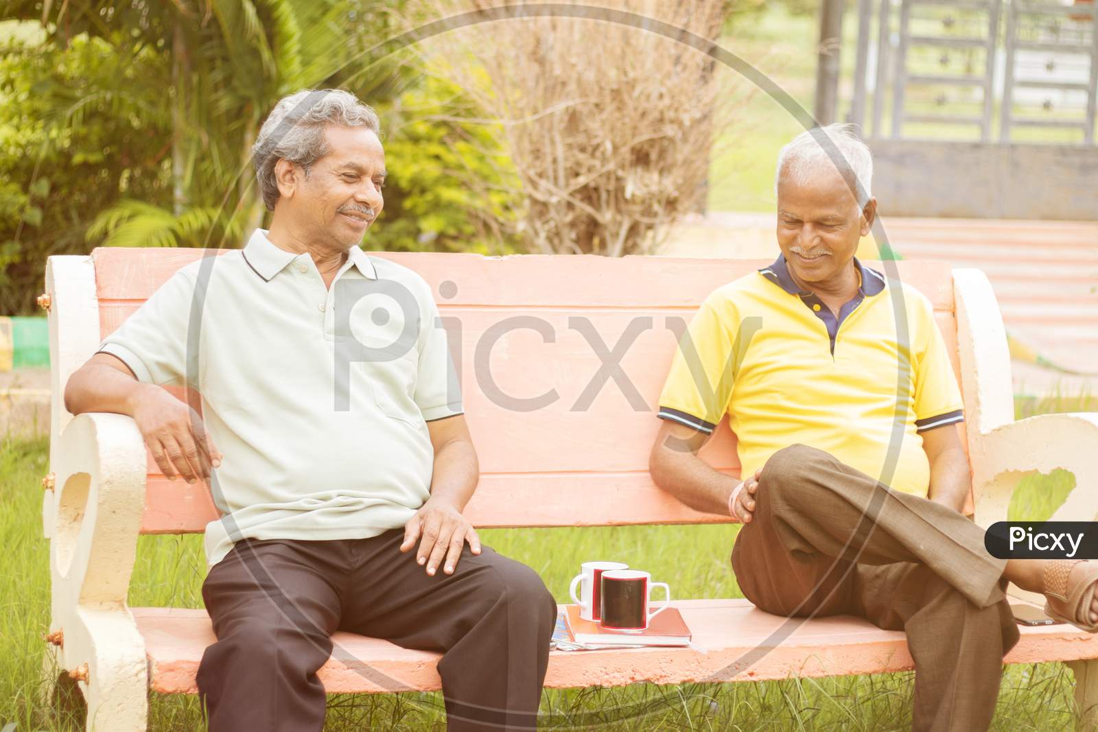Active Retired Old Men And Leisure Concept - Two Senior Friends Talking Outdoor During Evening Time With Coffee - Two Elderly Brothers Having Happy Time.