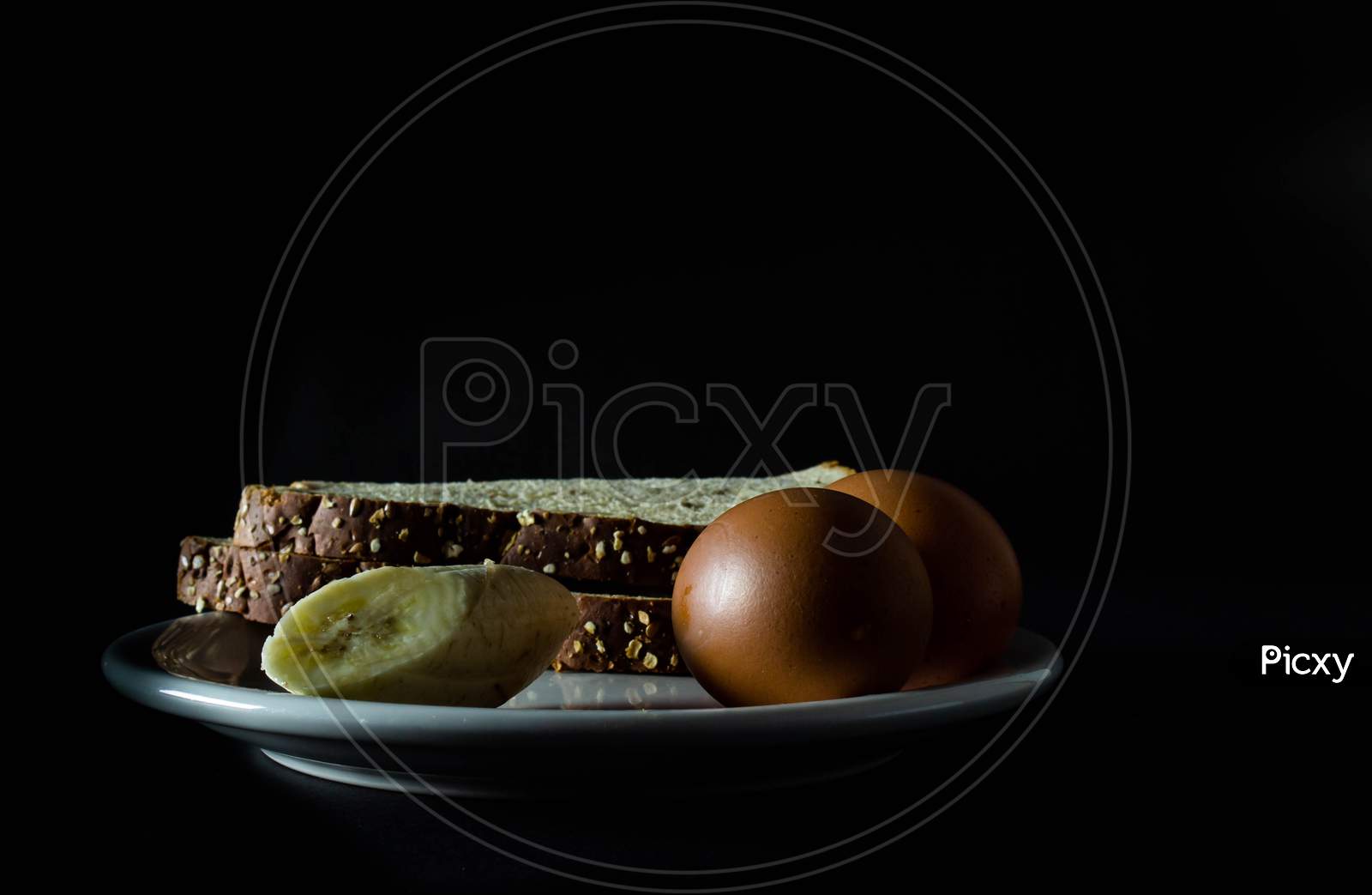 Varied Food To Prepare A Healthy Breakfast. Neutral Black Background With Pictorial Lighting. Healthy Diet Without Fats.