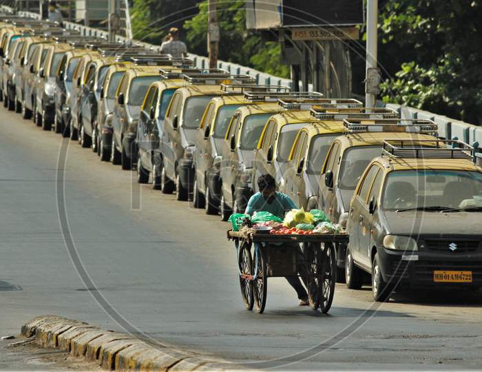 A vegetable seller wearing a protective mask walks past parked taxis during the nationwide lockdown to limit the spreading of coronavirus disease (COVID-19) in Mumbai, India on April 20, 2020.
