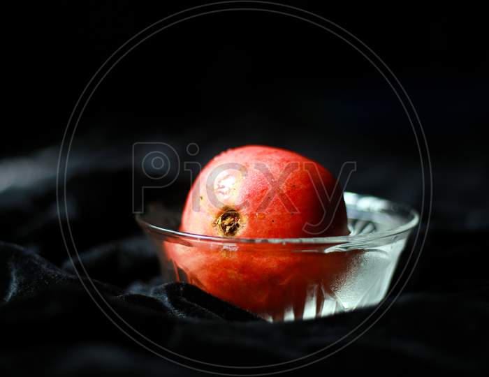 Pomegranate in transparent bowl with dark background