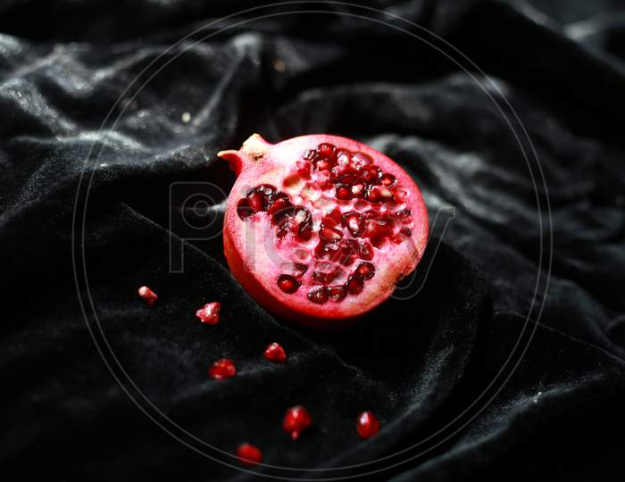 Fresh juicy pomegranate piece on dark background
