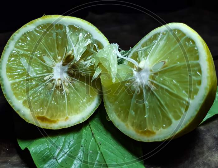 On A Black Background There Is A Half-Cut Lemon And It Contains Seed.