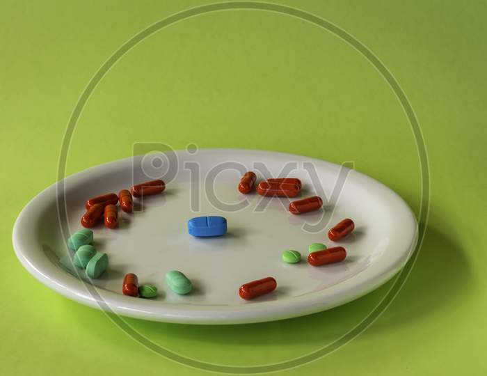 Colored Pills On A White Plate. Concept Of Social Distancing.