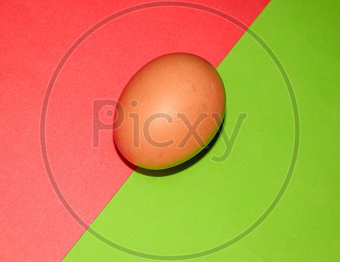 Brown colour egg on red green two colour background . Top view.