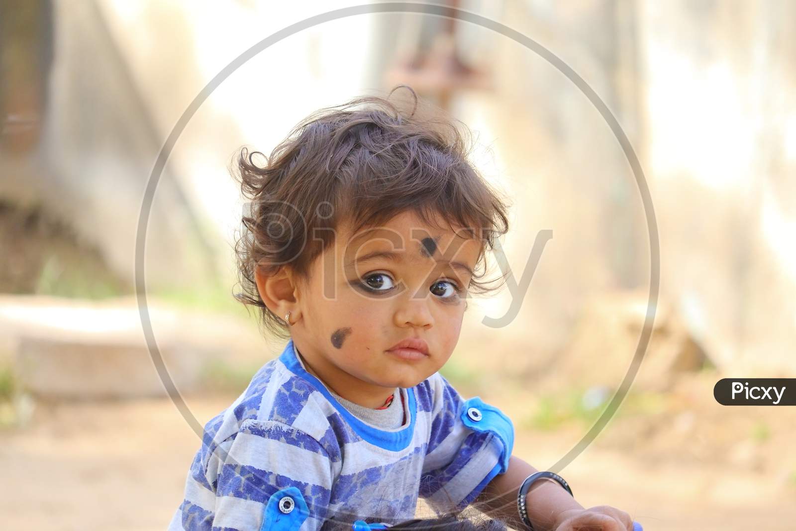 The Child Looking At The Camera With A Mascara In His Eyes