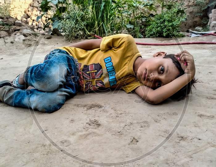 A sad child lying on the ground.