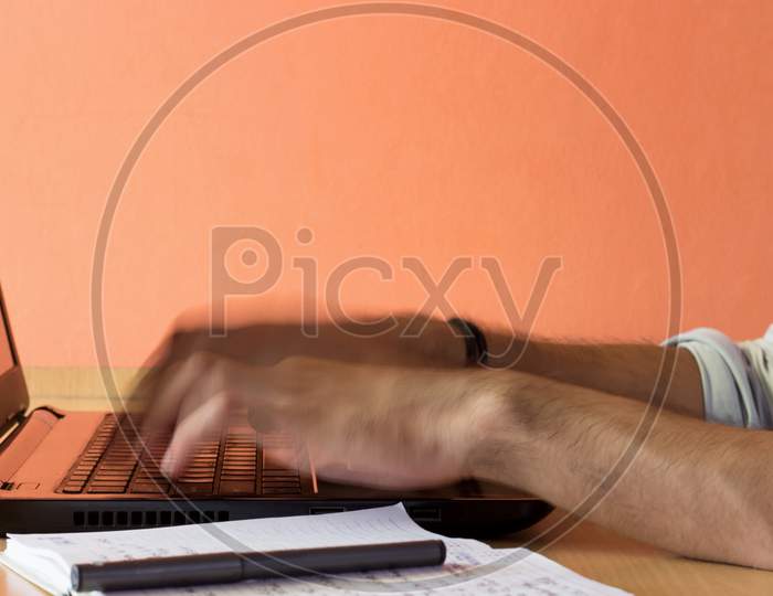 A male person typing on a Laptop