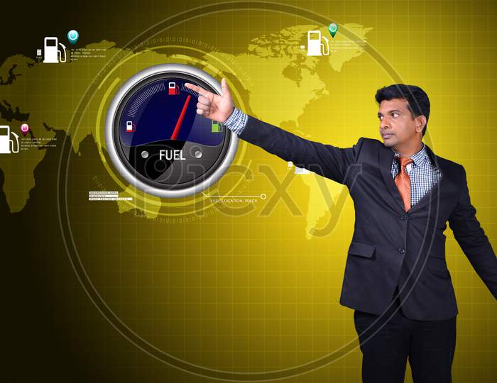 Young Indian Man pointing towards a Fuel Indicator
