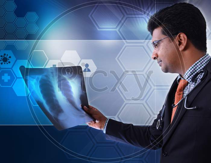 Male Doctor Looking At X-Ray