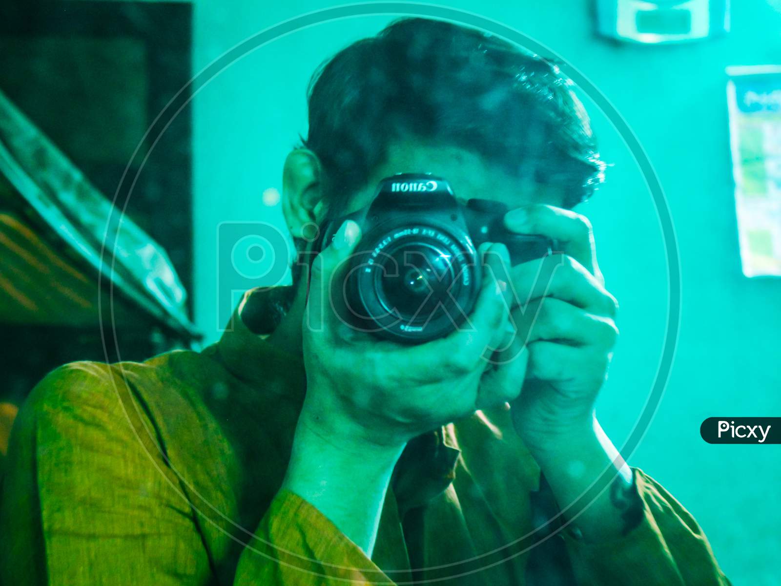 A Male Photographer taking himself Photo With Camera in the Front of a mirror at Home.