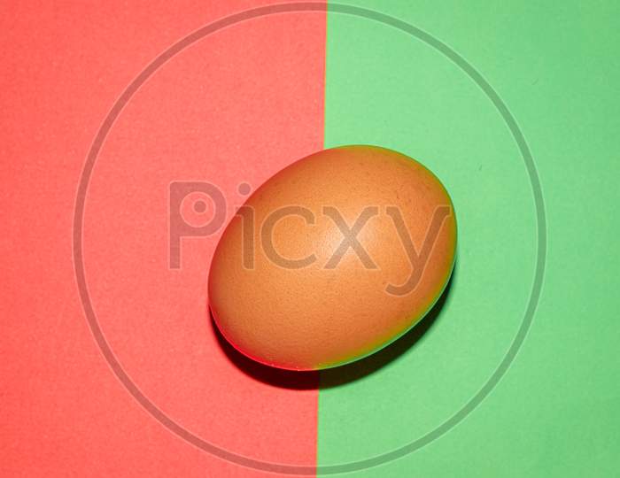 Brown colour  egg on red green  two colour background . Top view.