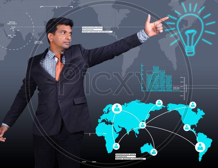 Young Indian Man Pointing towards a Bulb with World Map in the background