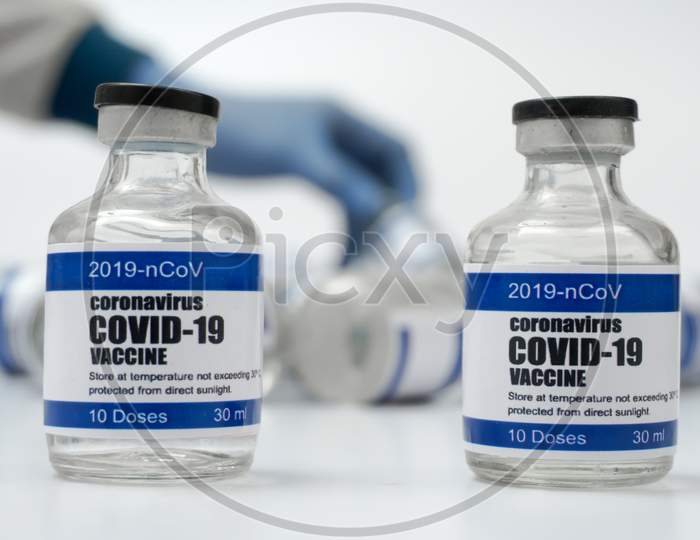 Covid-19 Corona Virus 2019-Ncov Vaccine Vials Medicine Drug Bottles Syringe Injection Blue Nitrile Surgical Gloves. Vaccination, Immunization, Treatment To Cure Covid 19 Corona Virus Infection Concept