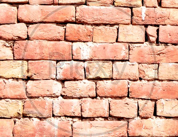 Vertical Shot Of A Brown Old Bricked Wall In Daylight