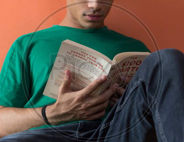 A Young Man Reading A Book.